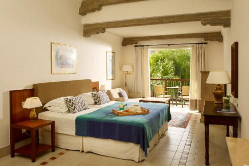 a bedroom with a bed with a table on it at Columbia Beach Resort in Pissouri