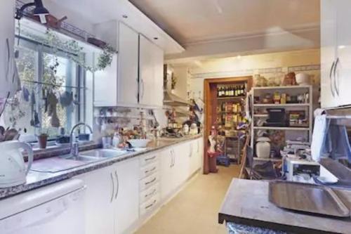 a large kitchen with white cabinets and a sink at At Home Sintra in Sintra