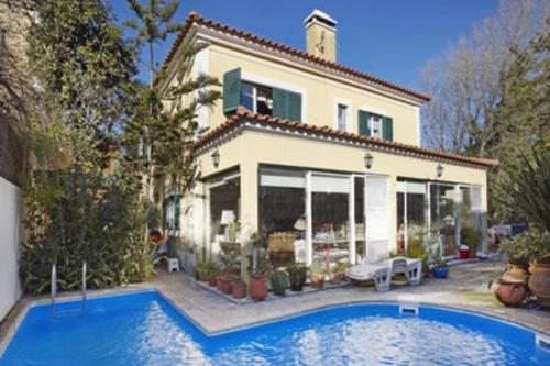a large house with a swimming pool in front of it at At Home Sintra in Sintra