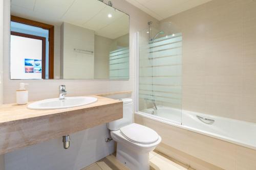 Un baño con inodoro, lavabo y ducha. en MILLENIUM 1 2-2, en Roses