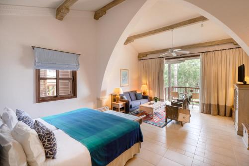 a bedroom with a large bed and a living room at Columbia Beach Resort in Pissouri