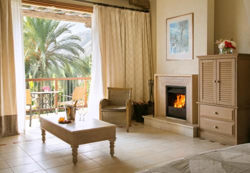 a living room with a fireplace and a table at Columbia Beach Resort in Pissouri