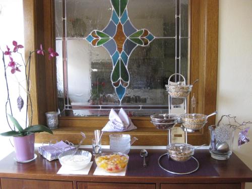 a table with a window with bowls and other items at Gästehaus Stroitz in Drobollach am Faakersee