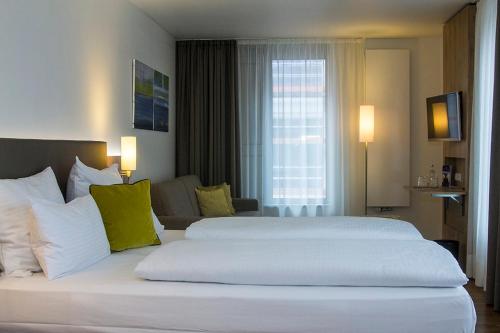 a large white bed in a hotel room at Hotel Goldenes Rad in Ulm