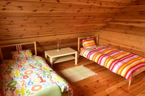 a room with two beds in a log cabin at Agroturystyka Rogoznia in Rogóżnia