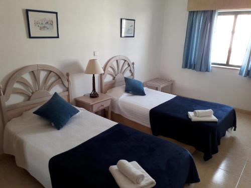 a hotel room with two beds with blue and white sheets at Dunas do Alvor apartment 146 in Alvor