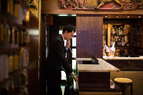 a man in a suit standing at a bar at Hotel Serenissima in Venice