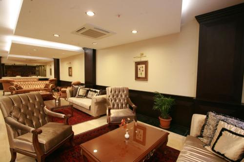 ein Wohnzimmer mit Stühlen, einem Sofa und einem Tisch in der Unterkunft Maywood Hotel in Istanbul