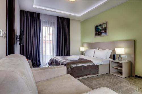 um quarto de hotel com uma cama e um sofá em Riva Residence em Herceg Novi