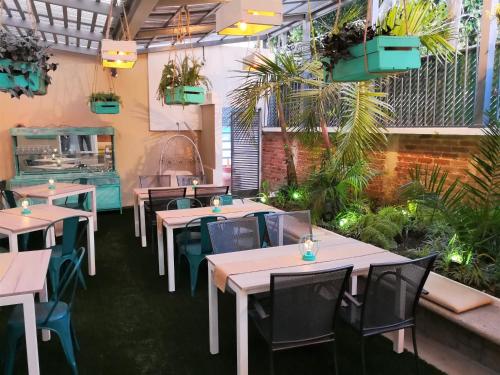 un restaurante con mesas, sillas y plantas en Meraki Boutique Hotel en Guatemala
