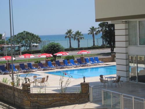 a swimming pool with chairs and umbrellas at Olbia Residence Hotel in Antalya