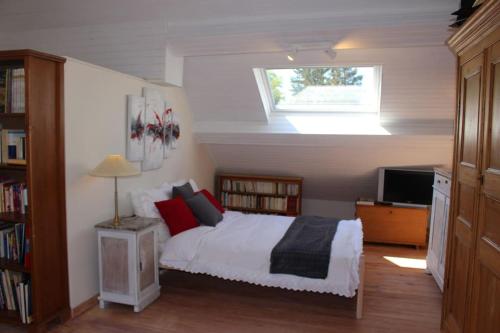 1 dormitorio con cama blanca y ventana en B & B Le Jardin Bed & Breakfasts, en Ménil
