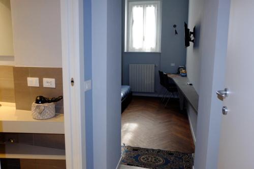 Cette chambre dispose d'un couloir avec une table et une fenêtre. dans l'établissement MONOLOCALE VICINO MILANO 2, à Lodi
