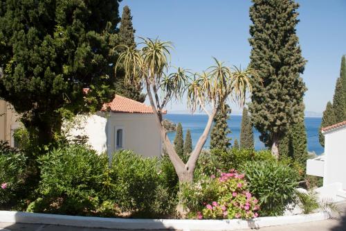 a garden in front of a house with trees and flowers at Kerveli Village Hotel in Kerveli