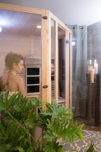 a woman sitting in a shower in a bathroom at Gothic Eves Inn and Spa Bed and Breakfast in Trumansburg