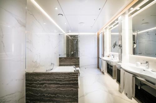 a bathroom with two sinks and a bath tub at Columbia Beach Resort in Pissouri