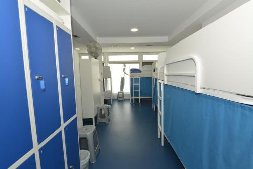 Habitación hospital con paredes azules y literas en Hostel Albergue Baionamar, en Baiona