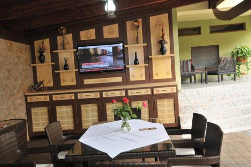 a dining room with a table and a tv on a wall at Pensiunea Normandia in Timişoara