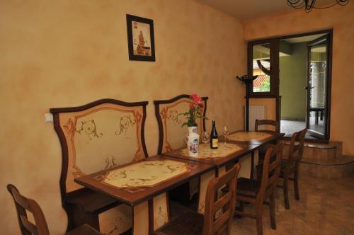 a dining room with a wooden table and chairs at Pensiunea Normandia in Timişoara