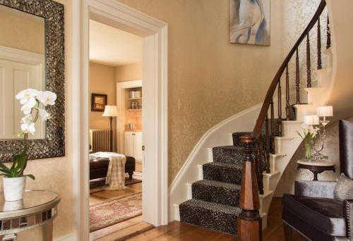 a living room with a staircase and a living room with a couch at Gothic Eves Inn and Spa Bed and Breakfast in Trumansburg