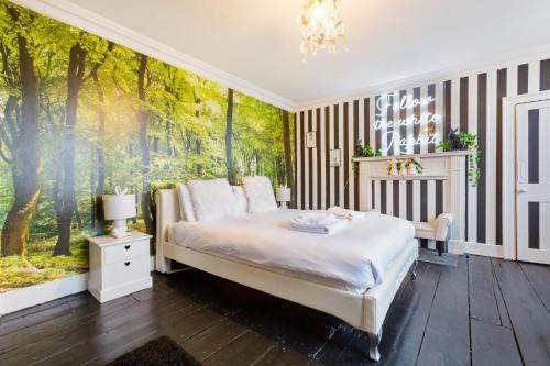 a bedroom with a large mural of trees at The Wonderland Townhouse - Alice in Wonderland 7BDR Home in Bath