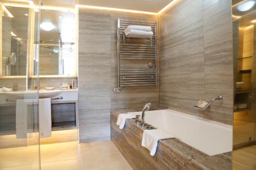a bathroom with a bath tub and a sink at Columbia Beach Resort in Pissouri