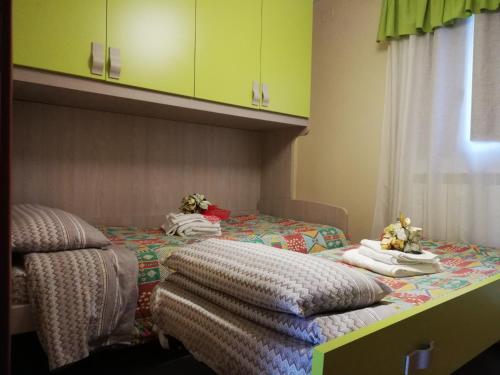 Duas camas individuais num quarto com armários verdes em B&B Villa Venere em Taranto