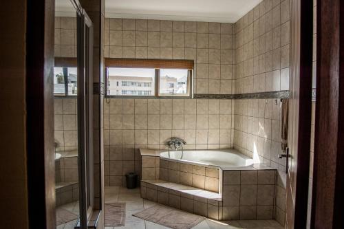 a bathroom with a tub and a window at Sea View Bliss Guesthouse with self Catering in Swakopmund