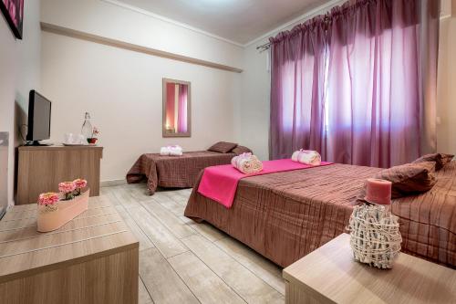 Habitación de hotel con 2 camas y TV en B&B Le Ortensie, en Fiumicino