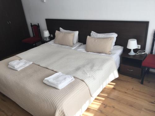 een slaapkamer met een groot bed en 2 handdoeken bij Iglika 2 Ski Apartment in Borovets