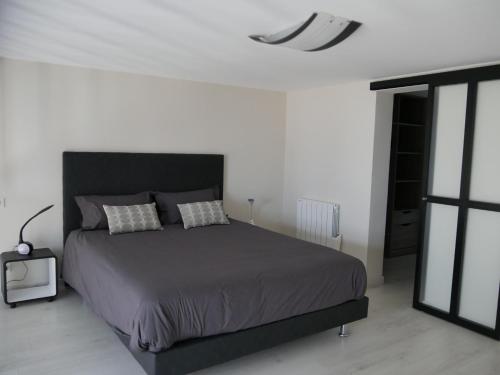 - une chambre avec un grand lit et une tête de lit noire dans l'établissement LOFT chic et moderne, déco industrielle, à Beausoleil