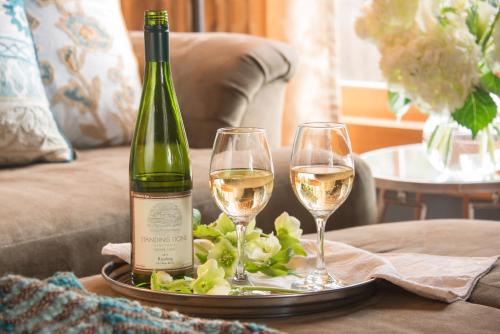 a bottle of wine and two glasses on a table at Gothic Eves Inn and Spa Bed and Breakfast in Trumansburg
