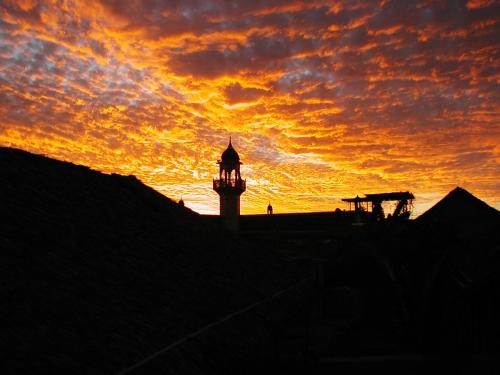 a silhouette of a clock tower at sunset at Patio dos quintalinhos - Casa di Gabriele in Ilha de Moçambique