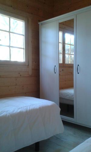 1 dormitorio con cama y espejo en Casita de madera junto al mar, en El Puerto de Santa María