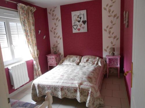 a bedroom with a bed with red walls and a window at Gite Halia beauval in Seigy