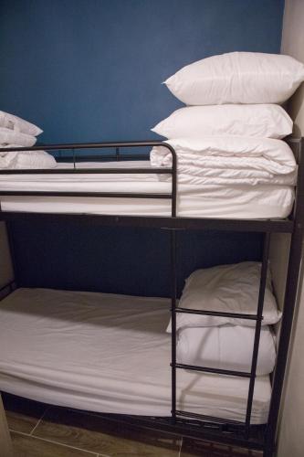 - un lit superposé avec des draps blancs et des oreillers dans l'établissement Castel des roches Leal Julien, à Saint-Gervais-les-Bains