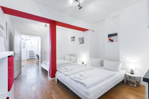 Duas camas num quarto com paredes brancas e vermelhas em DR APARTMENTS em Berlim