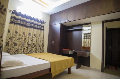 Dormitorio pequeño con cama y espejo en Aikya en Mangalore
