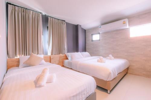 une chambre d'hôtel avec 2 lits avec des animaux rembourrés dans l'établissement 64House, à Chiang Mai