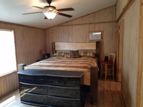 a bedroom with a bed and a ceiling fan at The Sandstone - A 3BR, 2BA Deluxe Log Cabin in Genoa