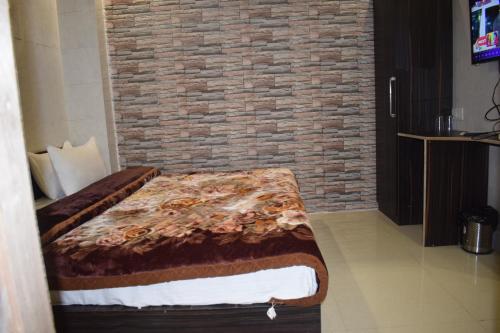 a bed in a room with a brick wall at Hotel Star Light in Amritsar