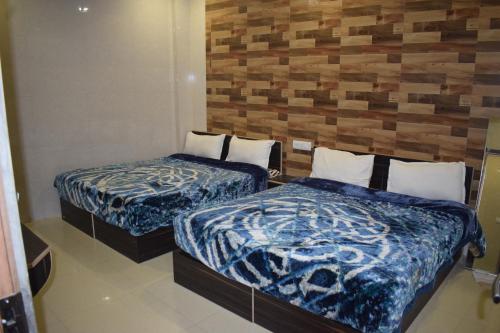 two beds in a hotel room with blue blankets at Hotel Star Light in Amritsar