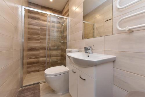 a bathroom with a toilet and a sink and a shower at Vila Dia Palanga in Palanga