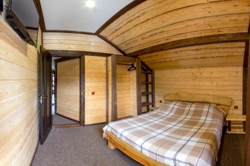 a bedroom in a log cabin with a bed at Guest House Plai in Yaremche