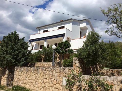 a white house on top of a stone wall at Willa Ferry **** in Prizna