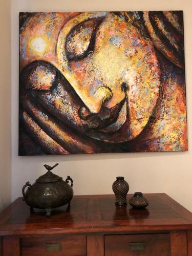 a painting hanging on a wall next to a wooden table at Palm Coast Luxury Rentals in Esterillos Este