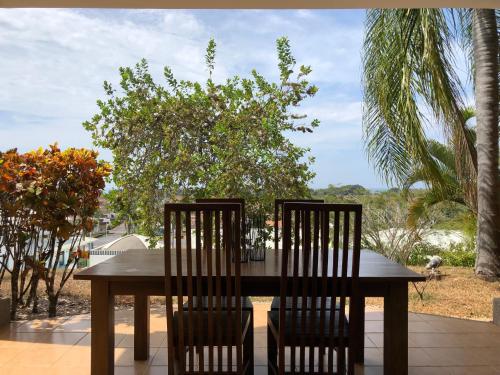 a wooden table with two chairs sitting around it at Palm Coast Luxury Rentals in Esterillos Este