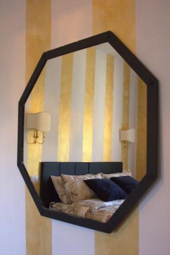 a mirror hanging on a wall above a bed at FiumicinoA57 in Fiumicino