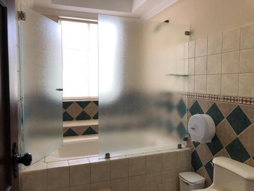 a bathroom with a shower with a glass door at Palm Coast Luxury Rentals in Esterillos Este