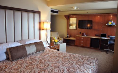 a hotel room with a large bed and a desk at Westmark Fairbanks Hotel and Conference Center in Fairbanks